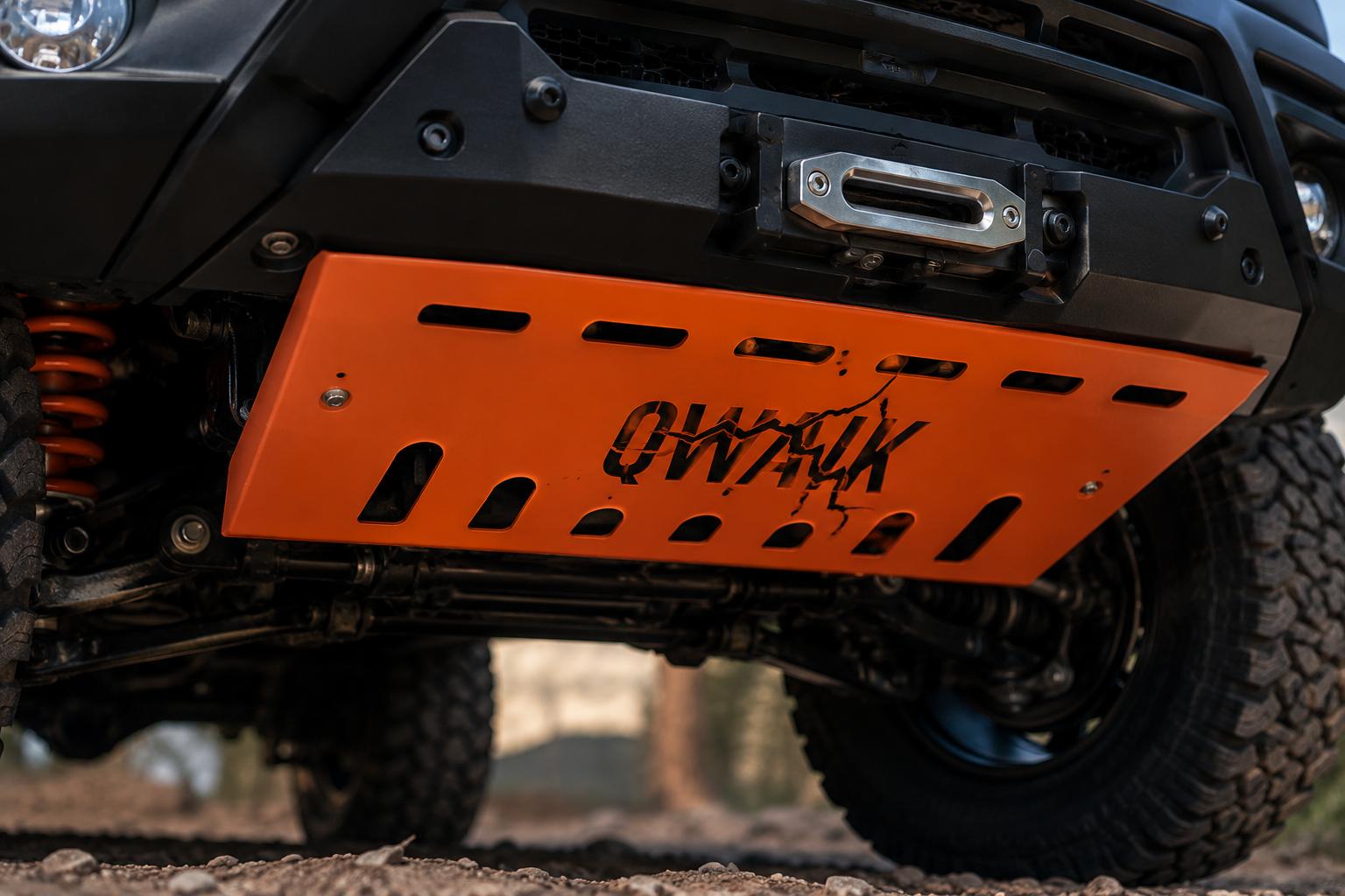 Close-up of the orange QWAIK laser-cut skid plate armour mounted under a 4x4